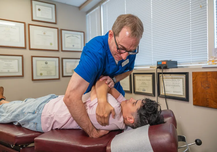 Dr. Paul Abosh performing a mid-back adjustment at Towson Integrative Health in Towson